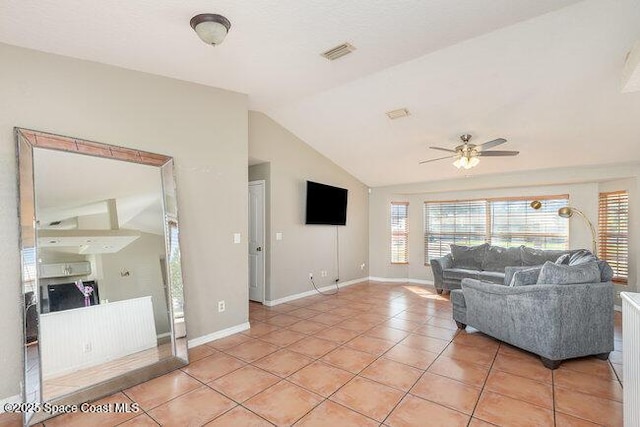 living area featuring vaulted ceiling, light tile patterned flooring, visible vents, and baseboards