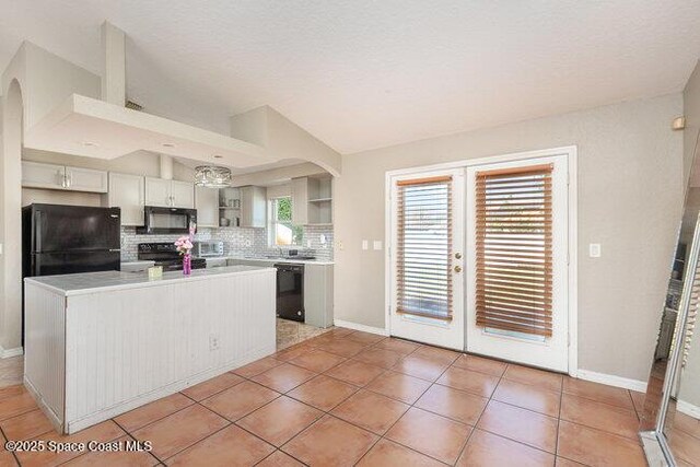 kitchen with black appliances, tasteful backsplash, arched walkways, and open shelves