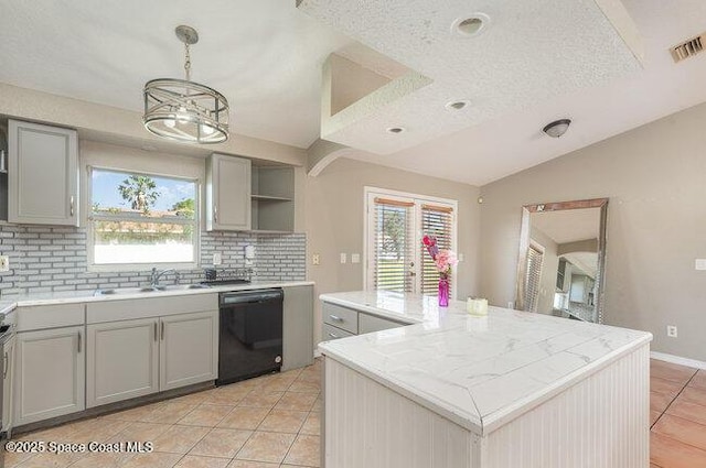 kitchen with visible vents, dishwasher, vaulted ceiling, gray cabinetry, and a sink