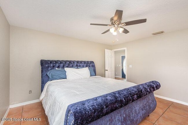 tiled bedroom featuring baseboards and a ceiling fan