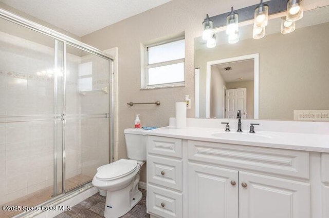 full bath with a stall shower, vanity, and toilet