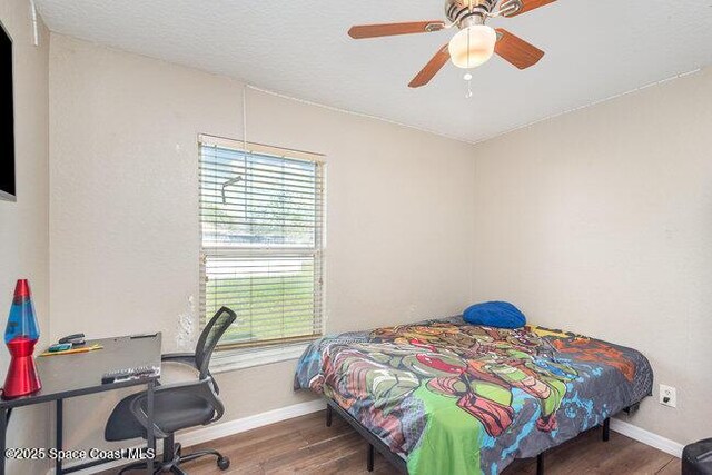 bedroom featuring wood finished floors, a ceiling fan, and baseboards