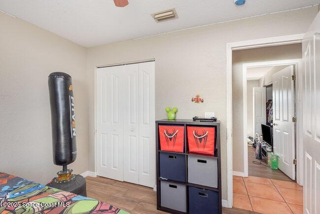 bedroom with a closet, visible vents, baseboards, and light tile patterned floors