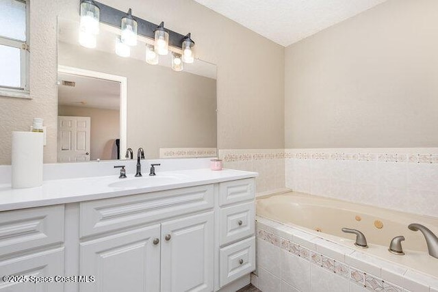 bathroom with a jetted tub and vanity