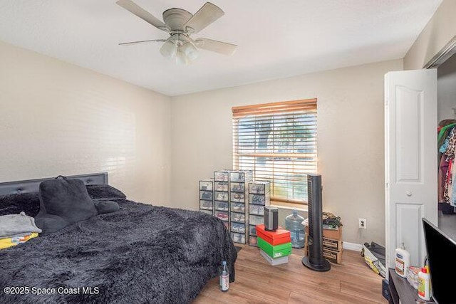 bedroom featuring ceiling fan, light wood-type flooring, and baseboards