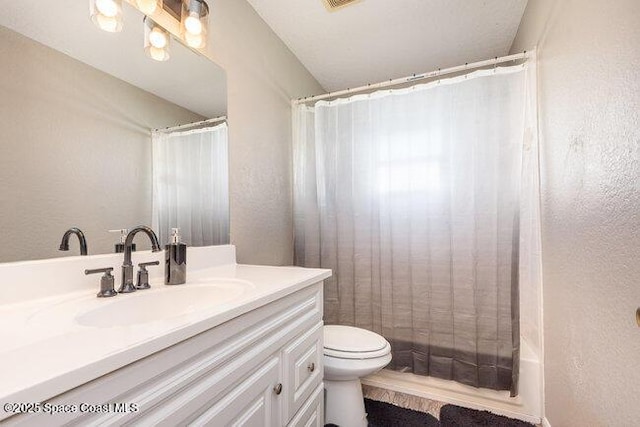 bathroom featuring toilet, a textured wall, visible vents, and vanity