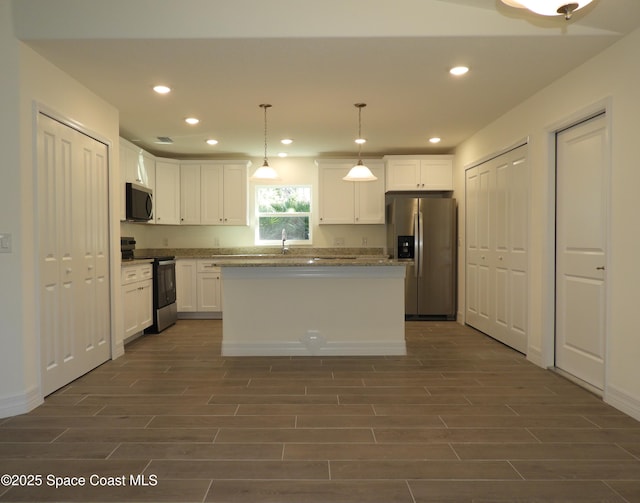 kitchen featuring recessed lighting, white cabinetry, appliances with stainless steel finishes, and wood finish floors