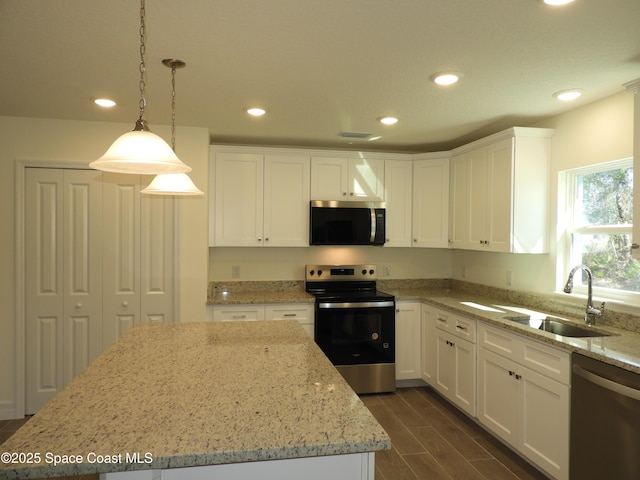 kitchen with recessed lighting, a sink, white cabinets, appliances with stainless steel finishes, and wood tiled floor