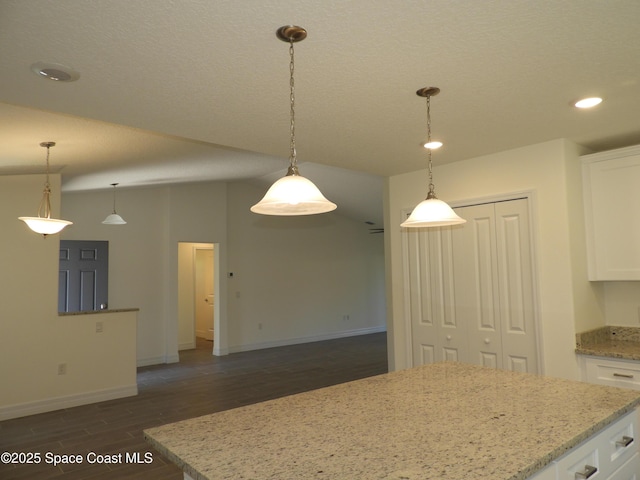 kitchen featuring a kitchen island, white cabinetry, dark wood finished floors, and pendant lighting