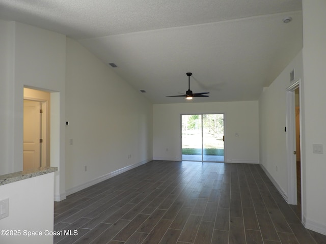 spare room featuring visible vents, baseboards, lofted ceiling, ceiling fan, and dark wood-style flooring