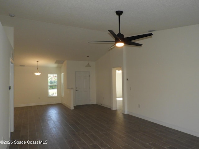 unfurnished room with dark wood-style floors, ceiling fan, vaulted ceiling, and baseboards