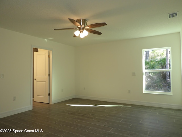 empty room featuring ceiling fan, wood finish floors, visible vents, and baseboards