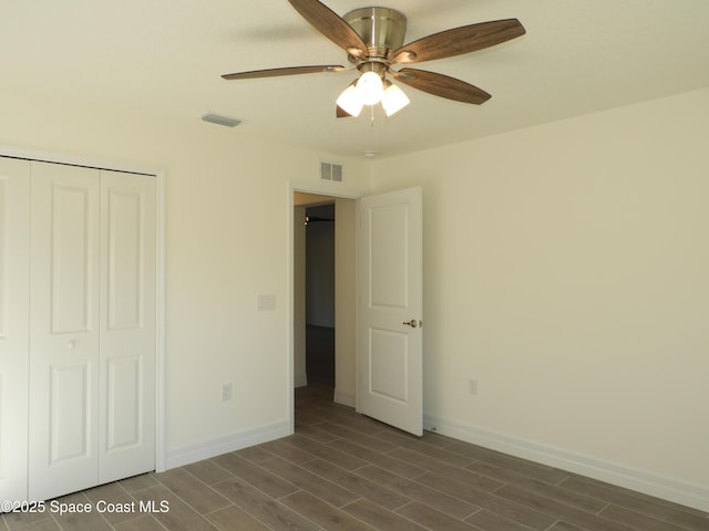 unfurnished bedroom featuring wood tiled floor, a closet, visible vents, and baseboards