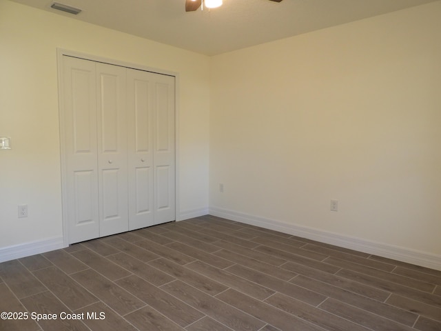 unfurnished bedroom featuring wood tiled floor, a closet, visible vents, and baseboards