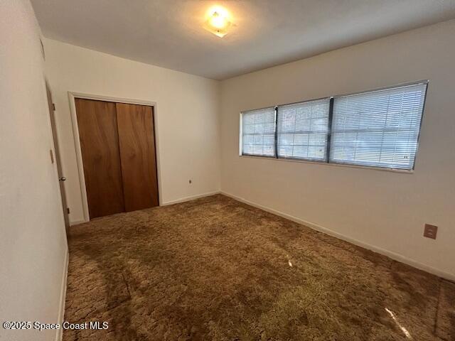 unfurnished bedroom with baseboards, a closet, and carpet floors