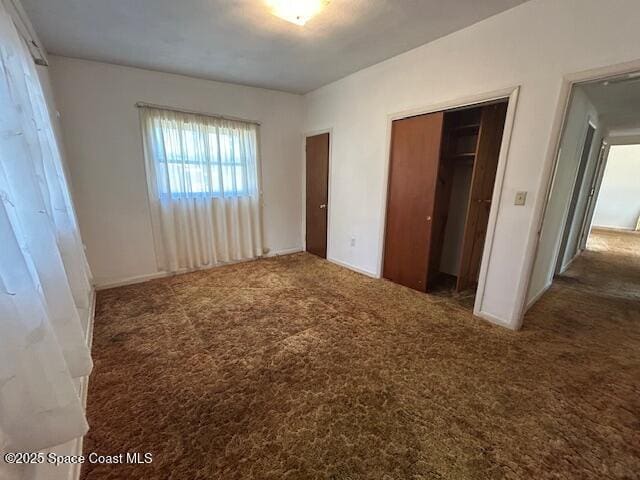 unfurnished bedroom with a closet and carpet floors