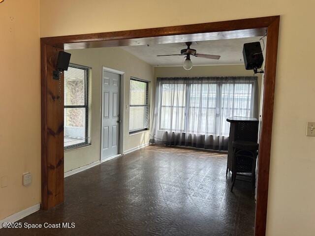 spare room featuring ceiling fan and baseboards