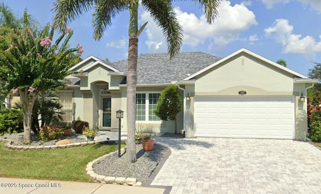 single story home with decorative driveway, a garage, and stucco siding