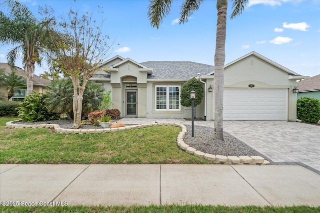 ranch-style home with stucco siding, a front lawn, decorative driveway, and a garage