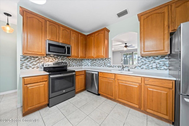 kitchen with visible vents, a sink, backsplash, appliances with stainless steel finishes, and light countertops