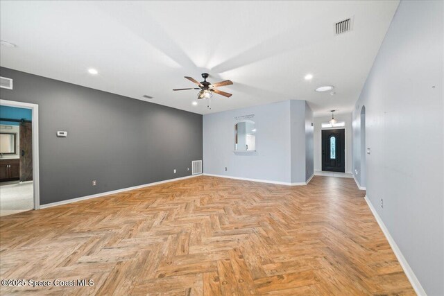 unfurnished room with visible vents, baseboards, and ceiling fan