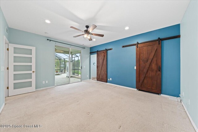 unfurnished bedroom with baseboards, carpet floors, recessed lighting, access to exterior, and a barn door