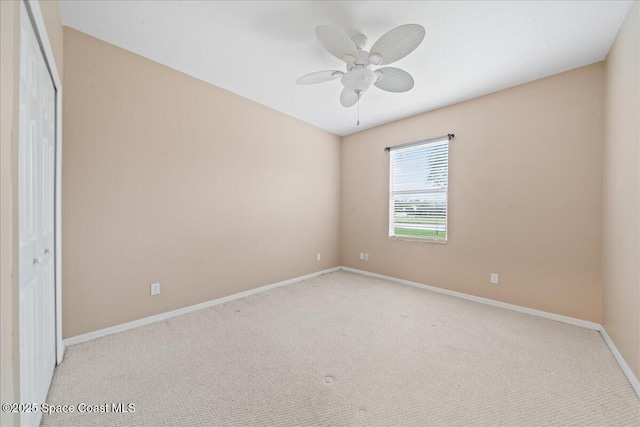 empty room featuring baseboards, carpet, and a ceiling fan