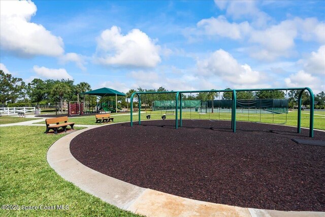 community jungle gym with a yard and fence