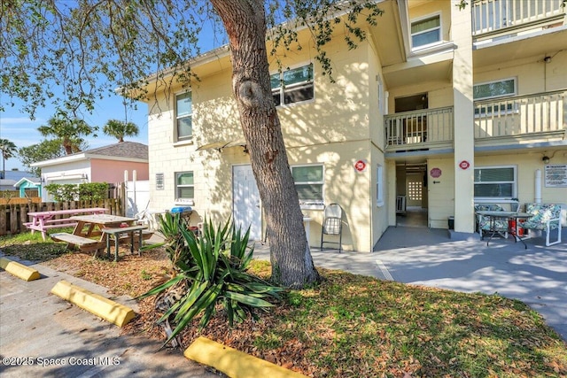 exterior space featuring a patio area, stucco siding, and fence