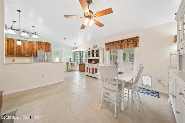 dining area with vaulted ceiling, ceiling fan, light tile patterned flooring, and baseboards