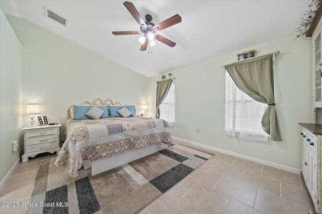 tiled bedroom featuring lofted ceiling, ceiling fan, visible vents, and baseboards