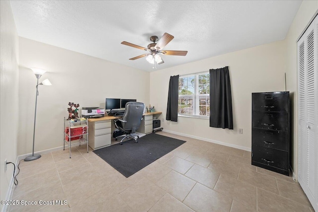 office space featuring a textured ceiling, baseboards, and light tile patterned floors