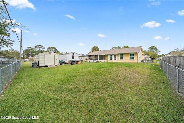 view of yard featuring a storage shed, an outbuilding, and a fenced backyard