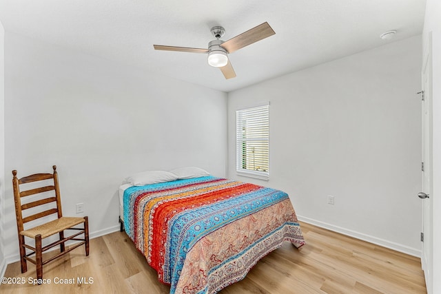 bedroom with a ceiling fan, baseboards, and wood finished floors