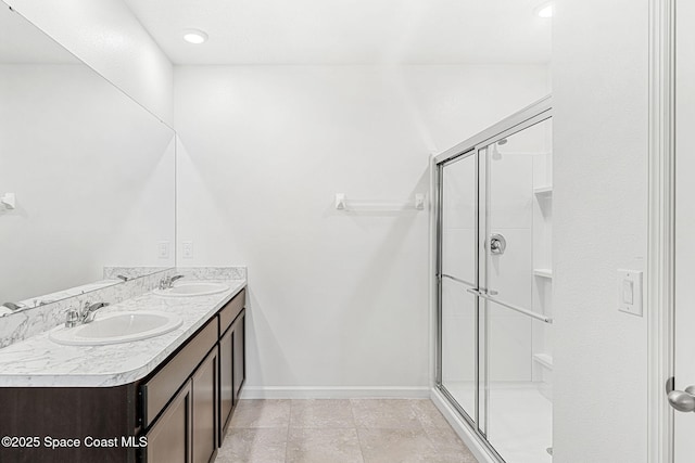 full bathroom with baseboards, a sink, and a shower stall