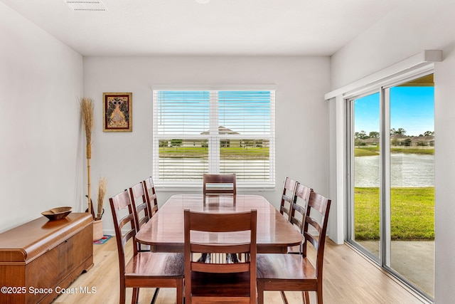 dining area featuring light wood-type flooring and visible vents