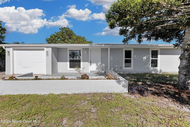 ranch-style home featuring a garage and stucco siding