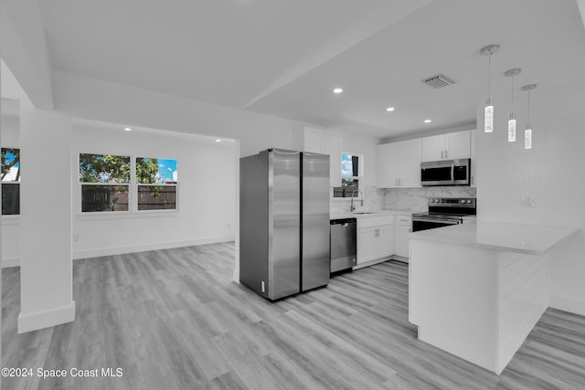 kitchen with a sink, visible vents, light countertops, appliances with stainless steel finishes, and decorative backsplash