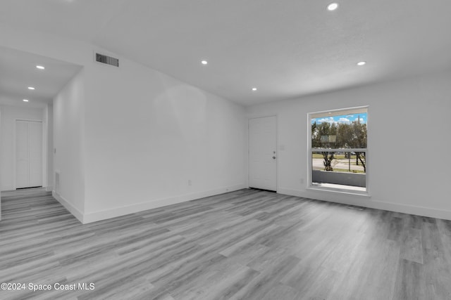 unfurnished room featuring baseboards, visible vents, wood finished floors, and recessed lighting