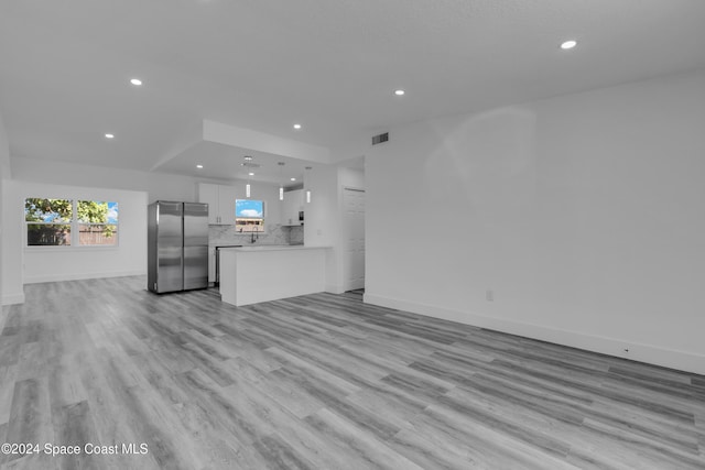 unfurnished living room featuring light wood-style flooring, visible vents, and recessed lighting