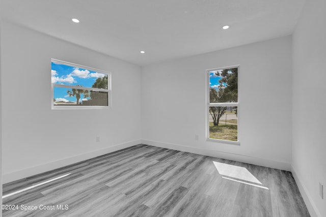 empty room with recessed lighting, plenty of natural light, and wood finished floors