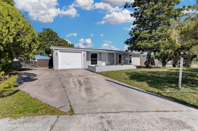 ranch-style home with a garage, concrete driveway, a front yard, and stucco siding