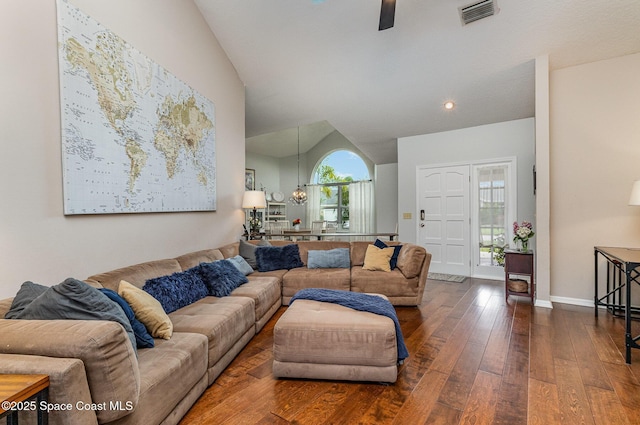 living area featuring visible vents, dark wood-type flooring, vaulted ceiling, baseboards, and ceiling fan with notable chandelier