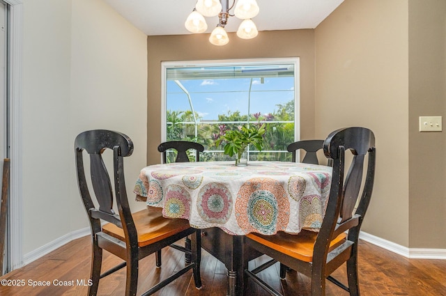 dining room with a chandelier, wood finished floors, and baseboards