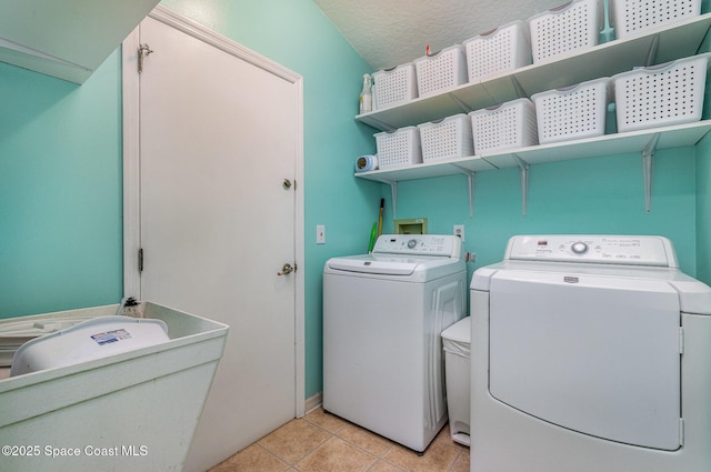 washroom featuring laundry area, independent washer and dryer, a textured ceiling, and light tile patterned floors