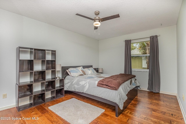 bedroom featuring a ceiling fan, a textured ceiling, and hardwood / wood-style flooring