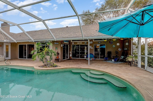 pool with a patio area and glass enclosure