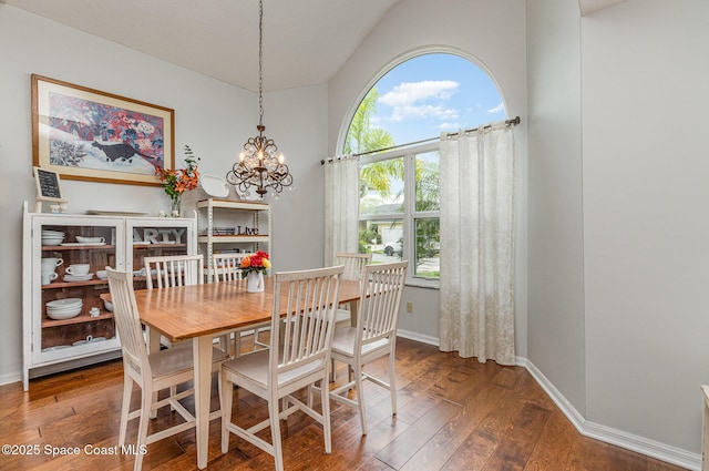 dining area featuring a chandelier, wood-type flooring, and baseboards