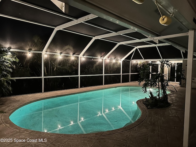 outdoor pool with glass enclosure and a patio