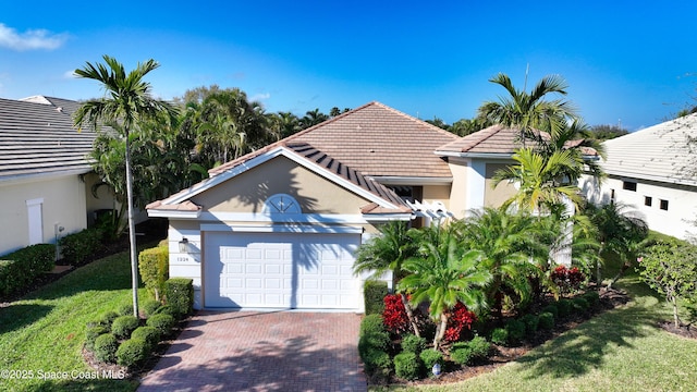 view of front facade featuring decorative driveway, a tile roof, stucco siding, an attached garage, and a front lawn